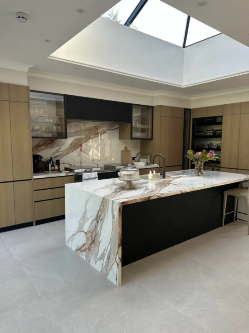 Kitchen with a marble island and clear worktops