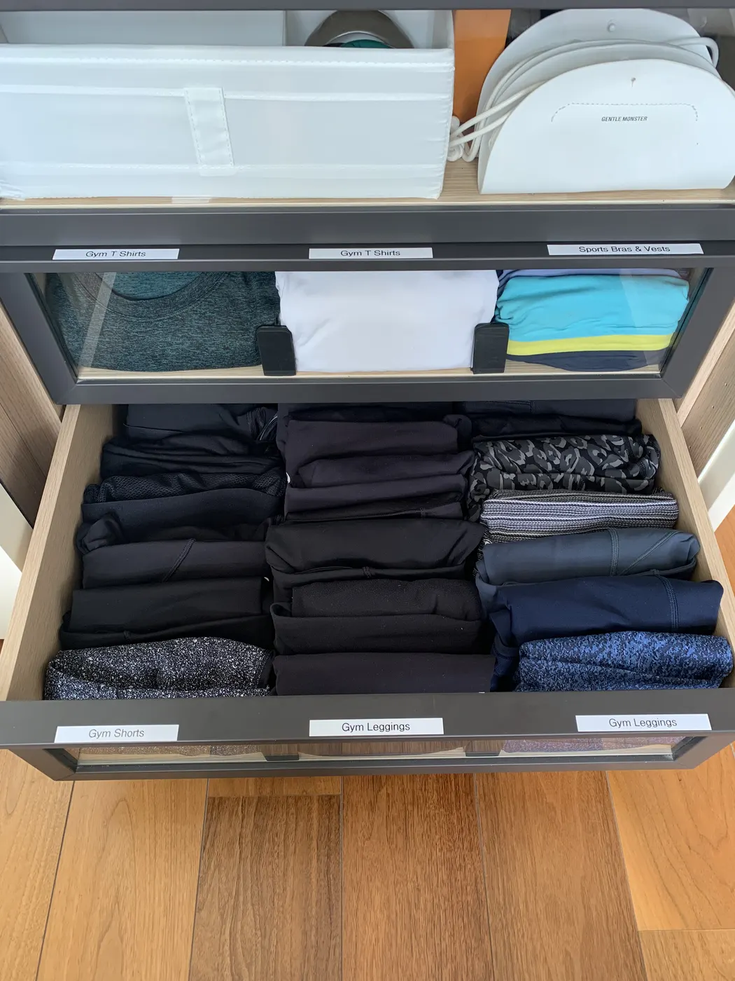 Wardrobe drawers with clothes folded upright and sorted by colour