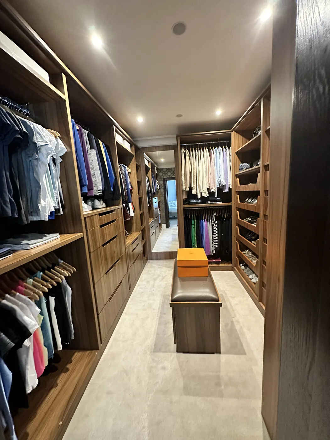 Walk-in dressing room after: clothes hung by colour and shoes lined up