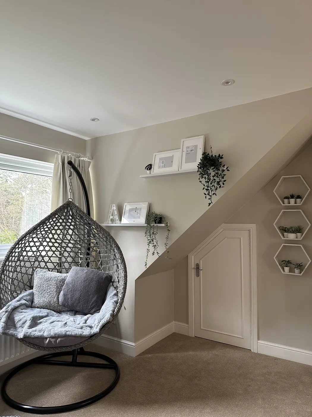 Finished bedroom corner with a hanging egg chair and wall shelves