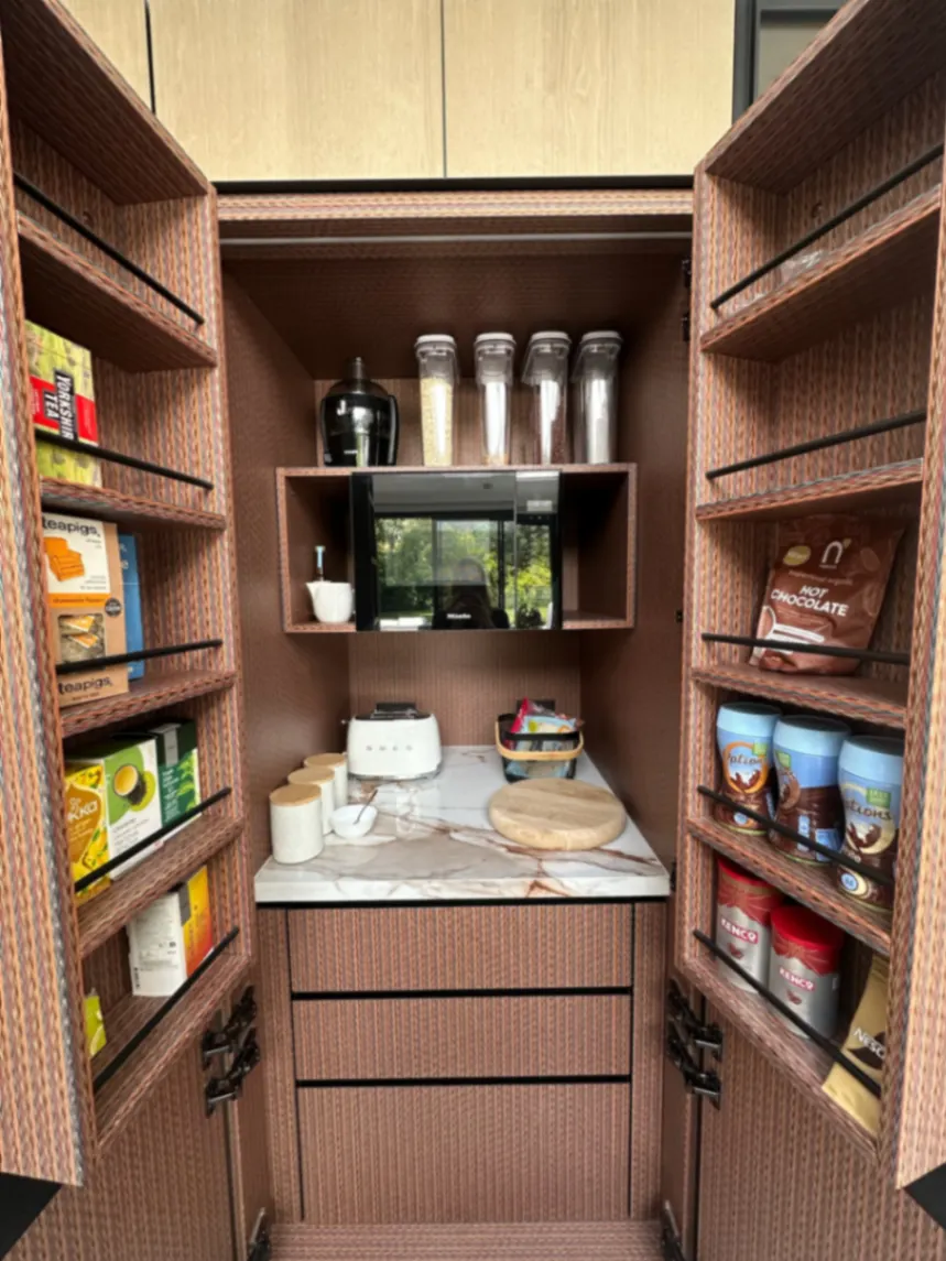 Walk-in pantry with organised food shelves and a clear worktop