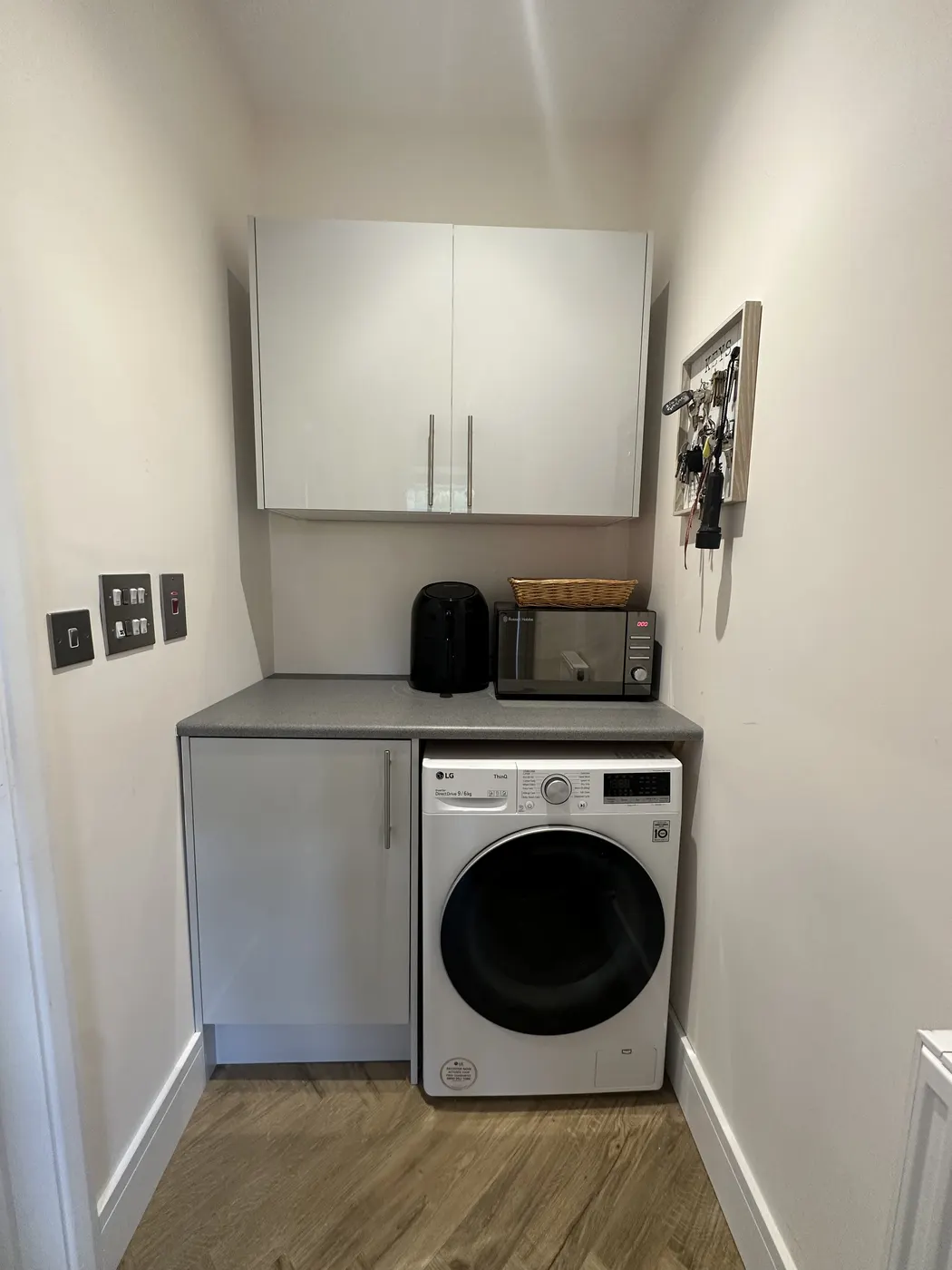 Utility room after: cupboards closed and worktop clear above the washing machine