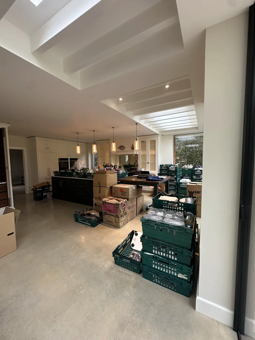 Open-plan kitchen with crates and boxes waiting to be unpacked