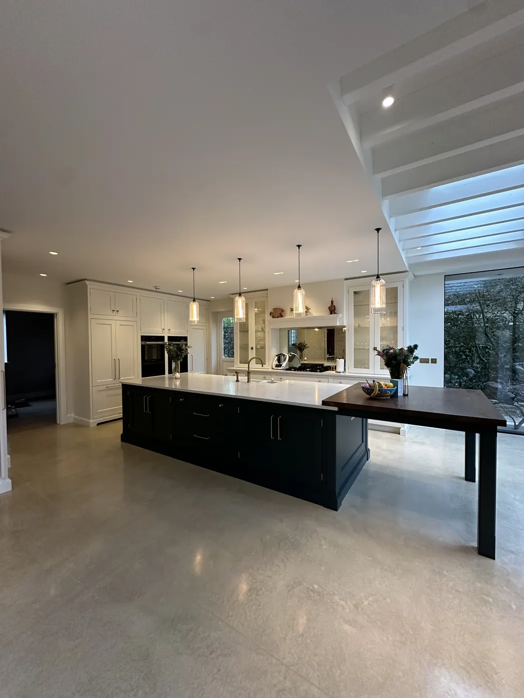 Open-plan kitchen fully unpacked with a clear island and dining table